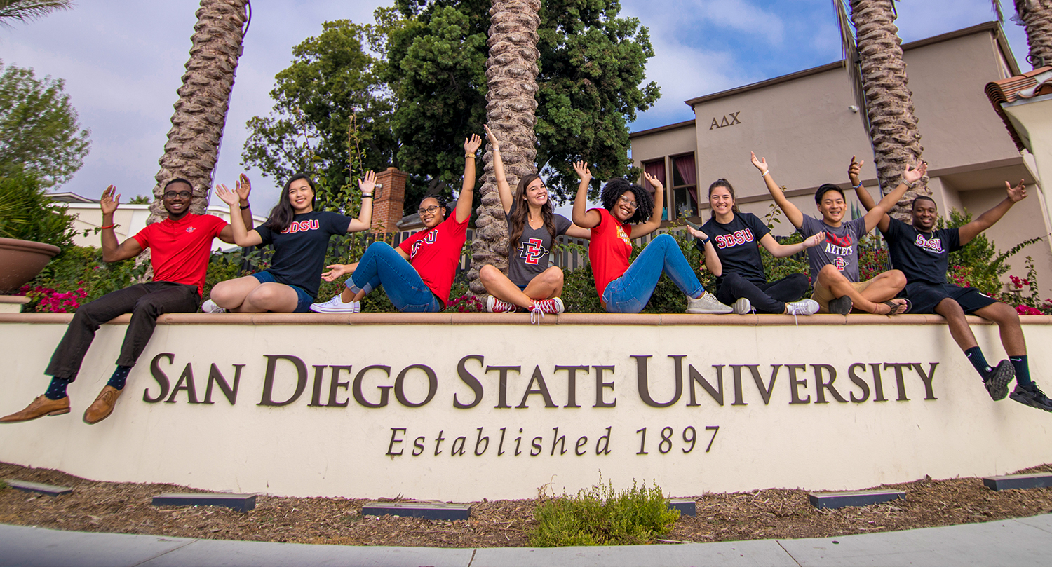 Students celebrating on top of SDSU Campus Sign